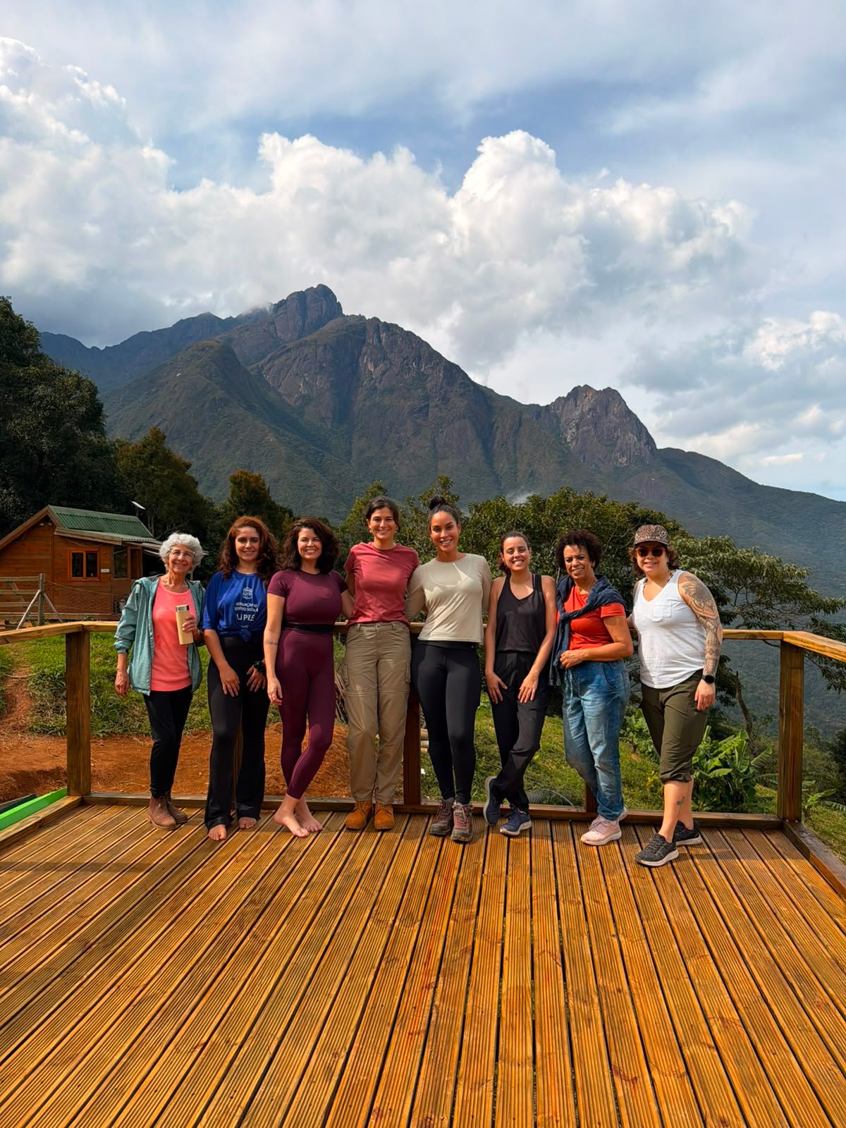 Grupo de participantes da vivência Raiz & Riso reunido com o Pico dos Marins ao fundo